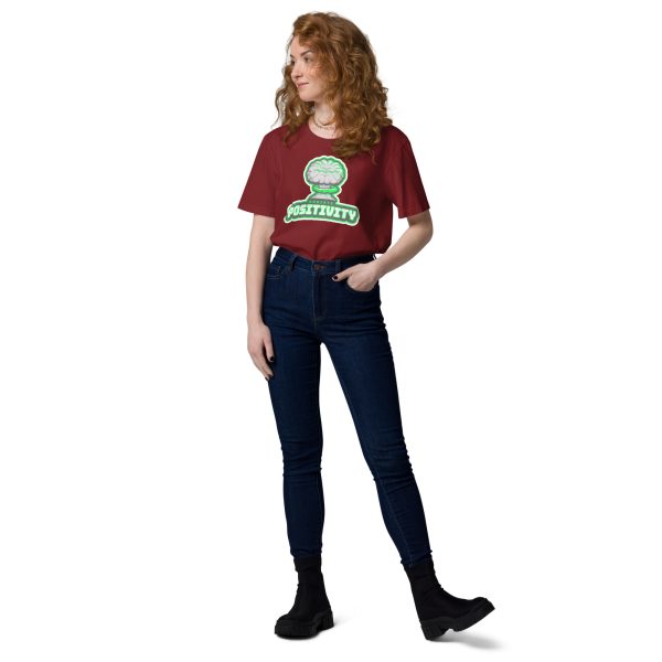 Woman looking at her right with her left hand in her pocket posing for a photo while wearing a t-shirt with the design of a nuclear bomb explosion with a green tint indicating radiation, with the quote "Radiate Positivity" below, this trying to be a radiation pun.