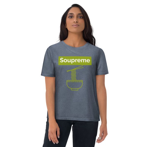 Woman with a neutral and confident pose looking directly at you while wearing a t-shirt that features a minimalistic and simple design of some chopsticks taking a bunch of ramen noodles from the ramen noodle bowl. Above there is a logo that reads: Soupreme; not being related to any particular brand and intended to be a joke or pun of the main subject of the design which in this case is ramen noodle soup.