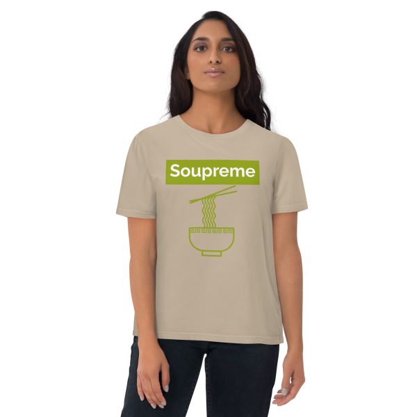 Woman with a neutral and confident pose looking directly at you while wearing a t-shirt that features a minimalistic and simple design of some chopsticks taking a bunch of ramen noodles from the ramen noodle bowl. Above there is a logo that reads: Soupreme; not being related to any particular brand and intended to be a joke or pun of the main subject of the design which in this case is ramen noodle soup.