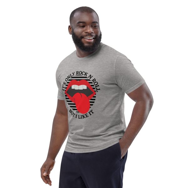 Strong muscular man smiling with his left hand on his pocket looking at his left while wearing a fitted t-shirt featuring a mouth open with a tongue out in the classical Rock n Roll style with the quote "It's Only Rock N Roll But I Like It", not intentionally related to any song or popular thing on the internet, just stating the facts.